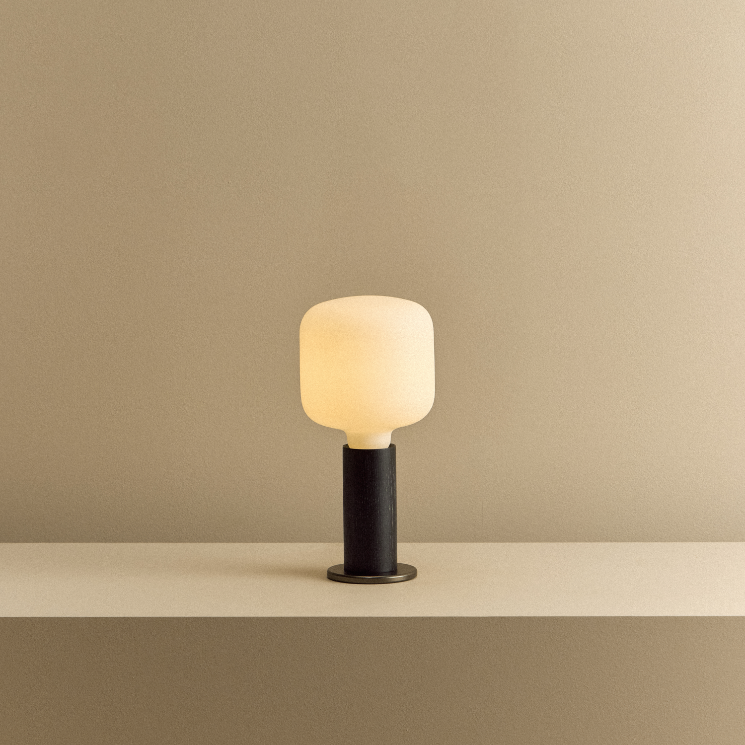 Tala Knuckle Table Lamp in Blackened Oak + Oblo shown illuminated