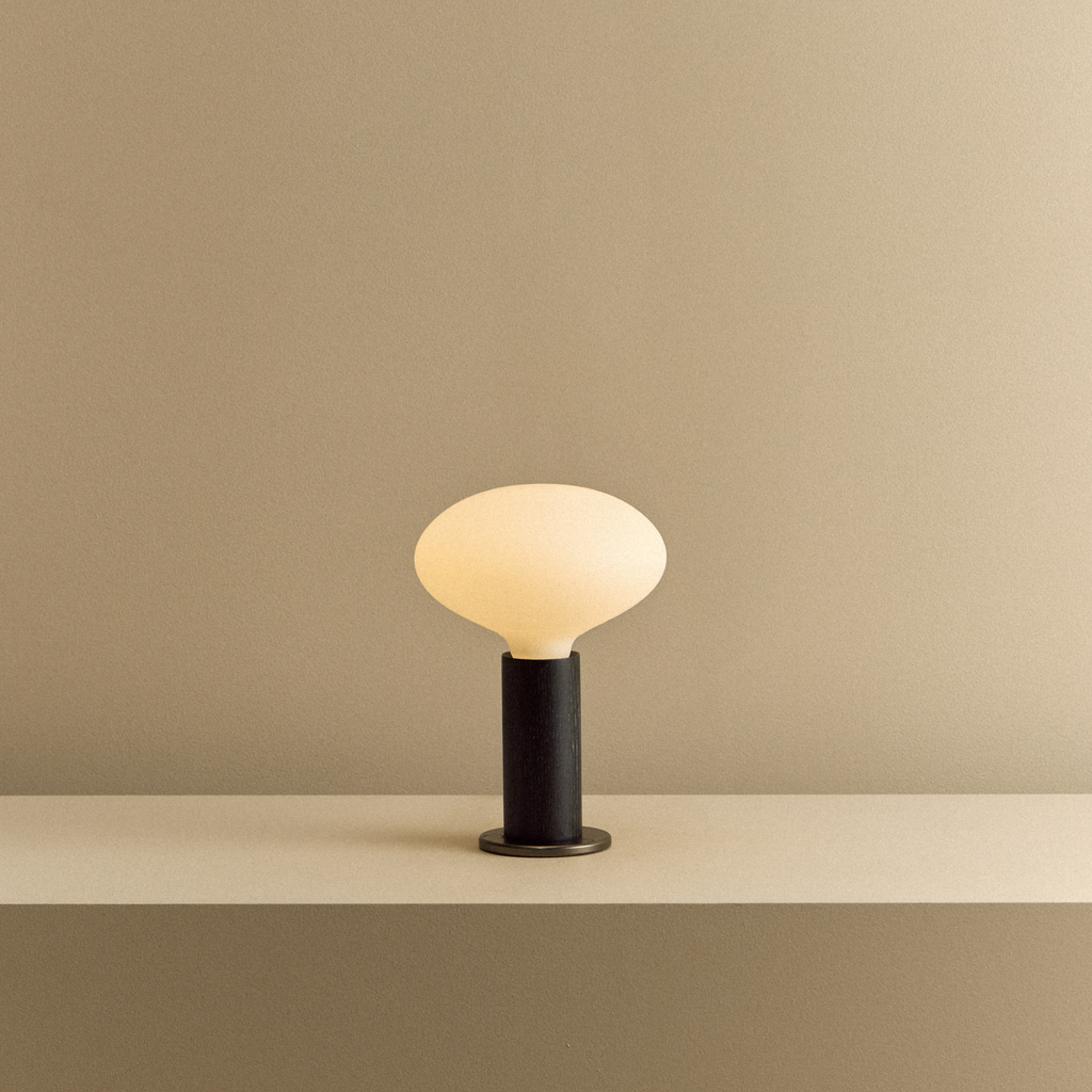 Tala Knuckle Table Lamp in Blackened Oak + Oval shown illuminated