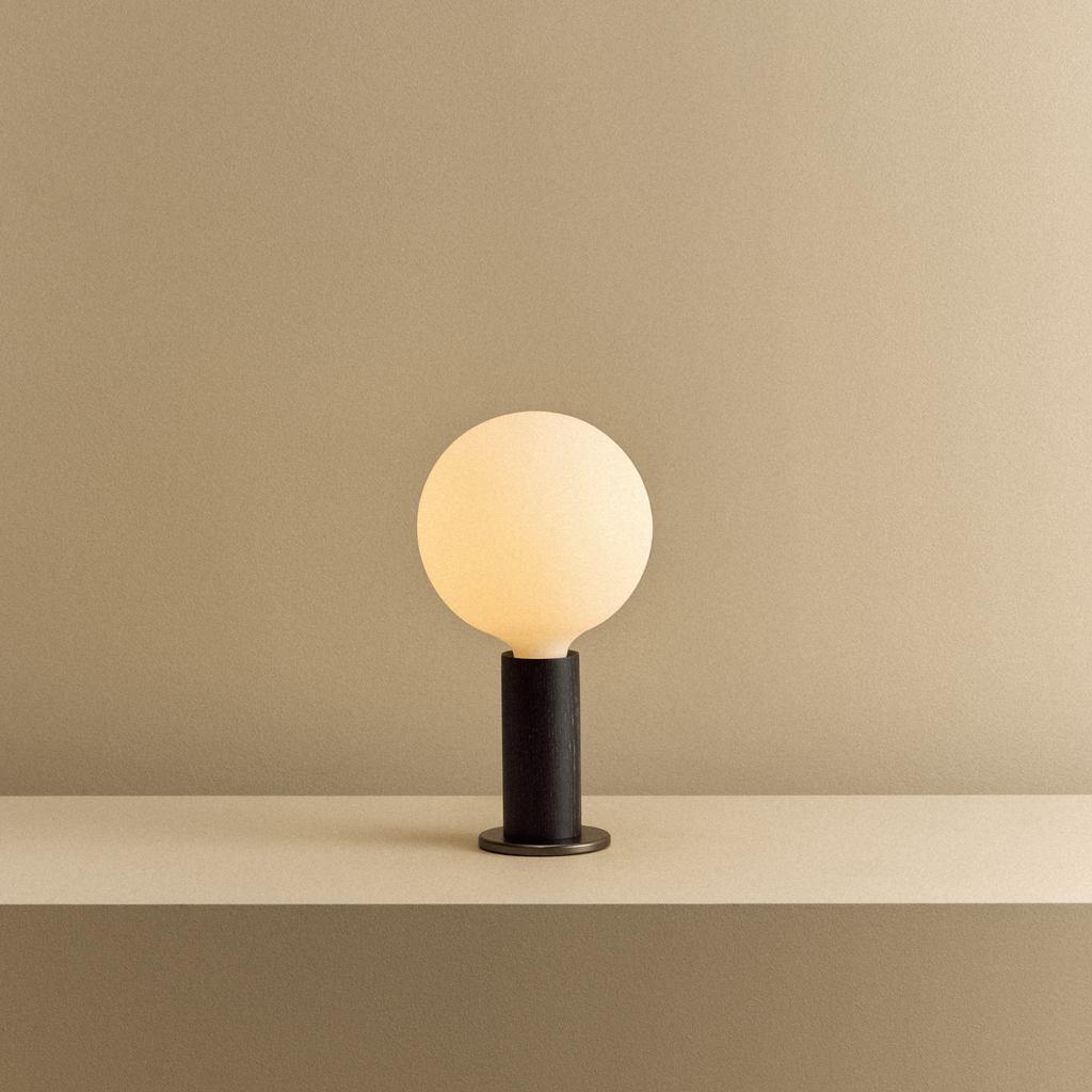 Tala Knuckle Table Lamp in Blackened Oak + Sphere IV shown illuminated