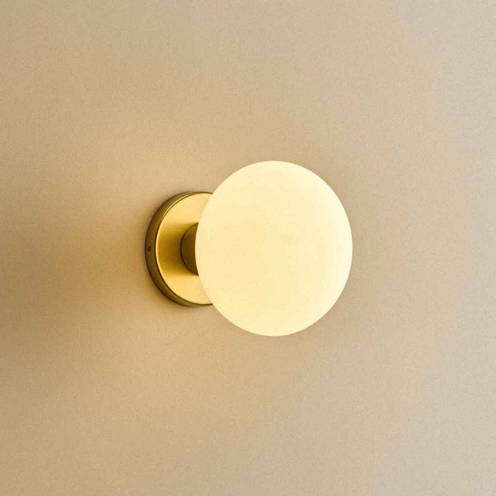 Tala Lochan Wall Light in Brass + Oval shown illuminated