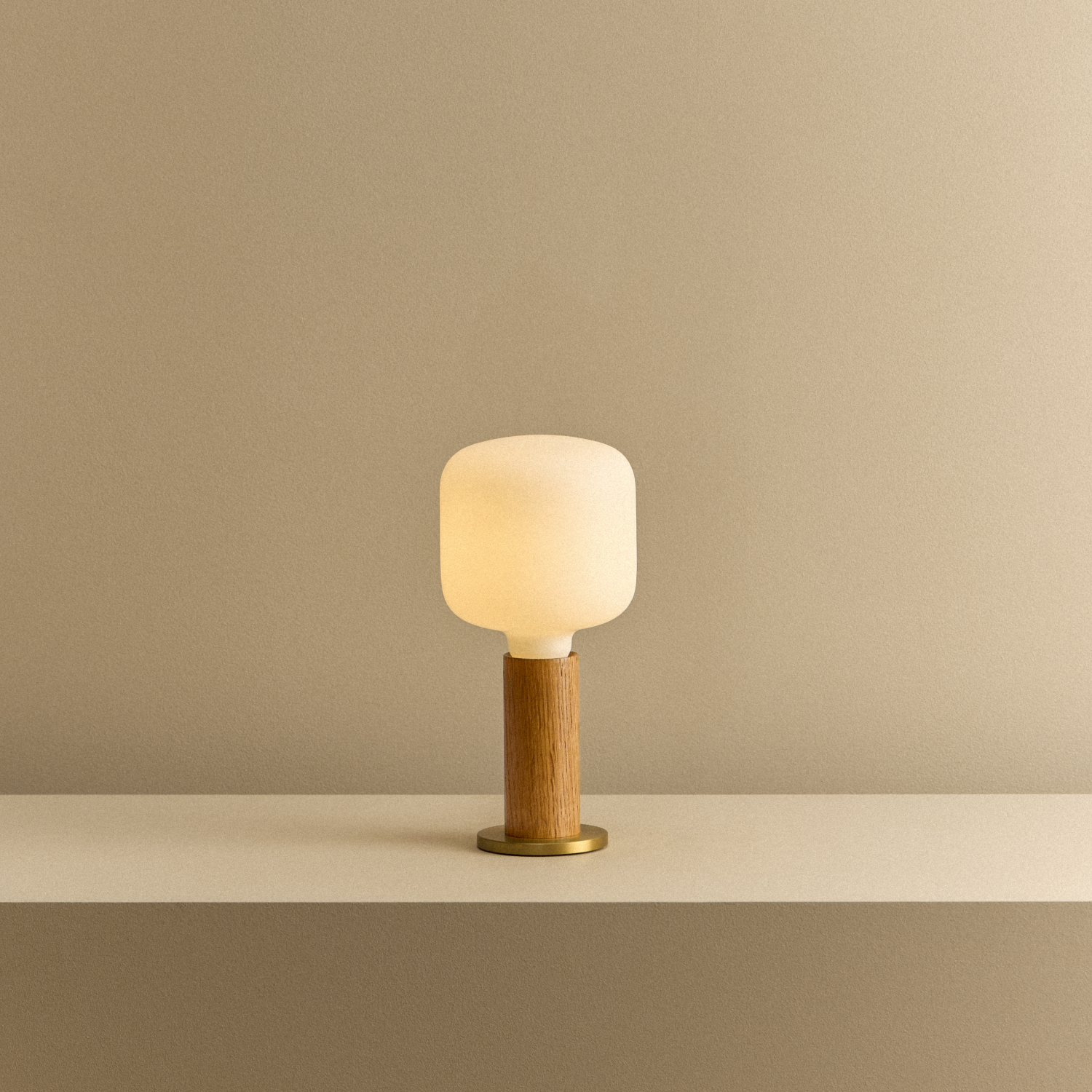 Tala Knuckle Table Lamp in Oak + Oblo shown illuminated