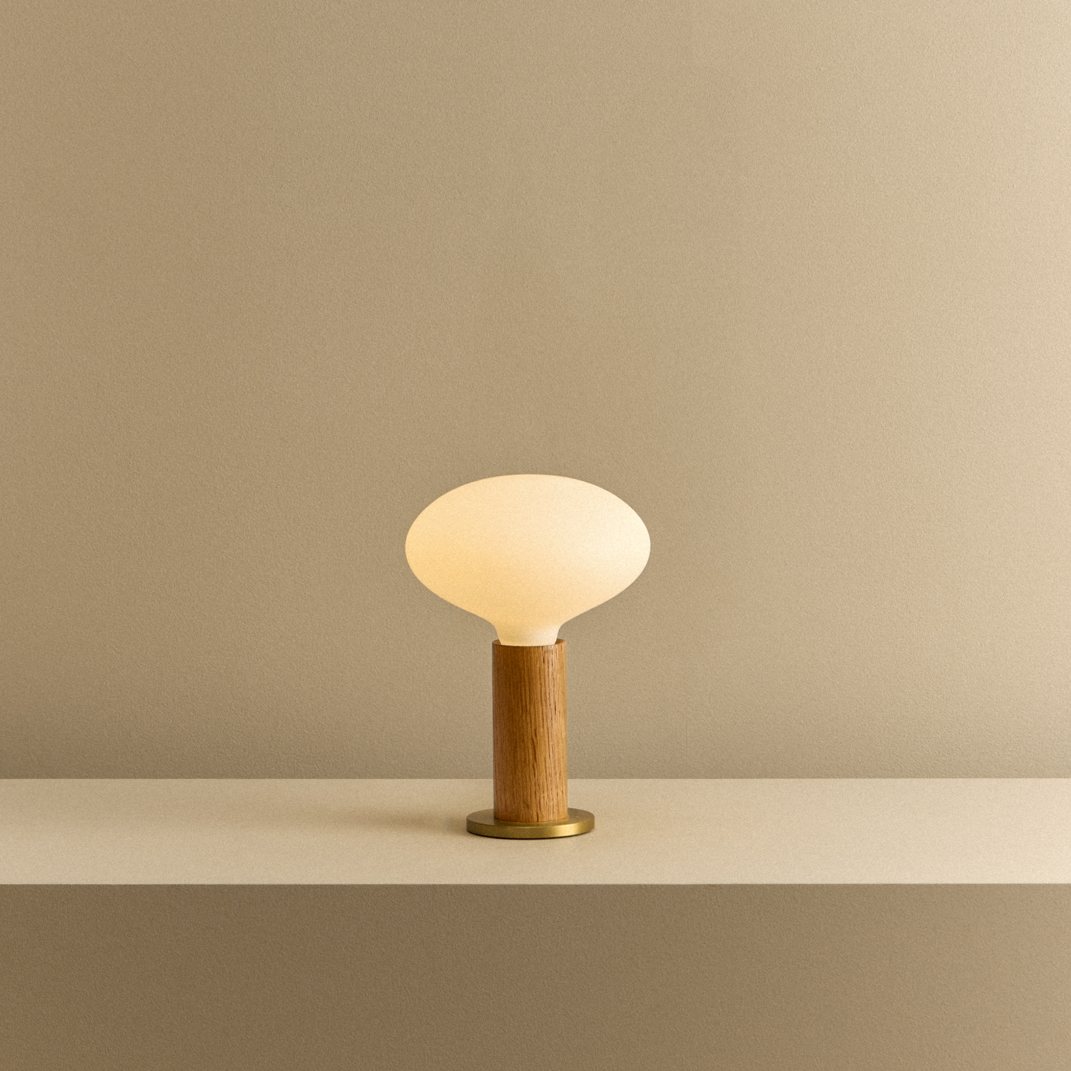 Tala Knuckle Table Lamp in Oak + Oval shown illuminated