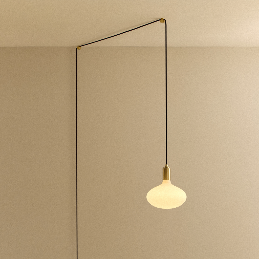Tala Oval II Plug-In Pendant in Brass shown illuminated