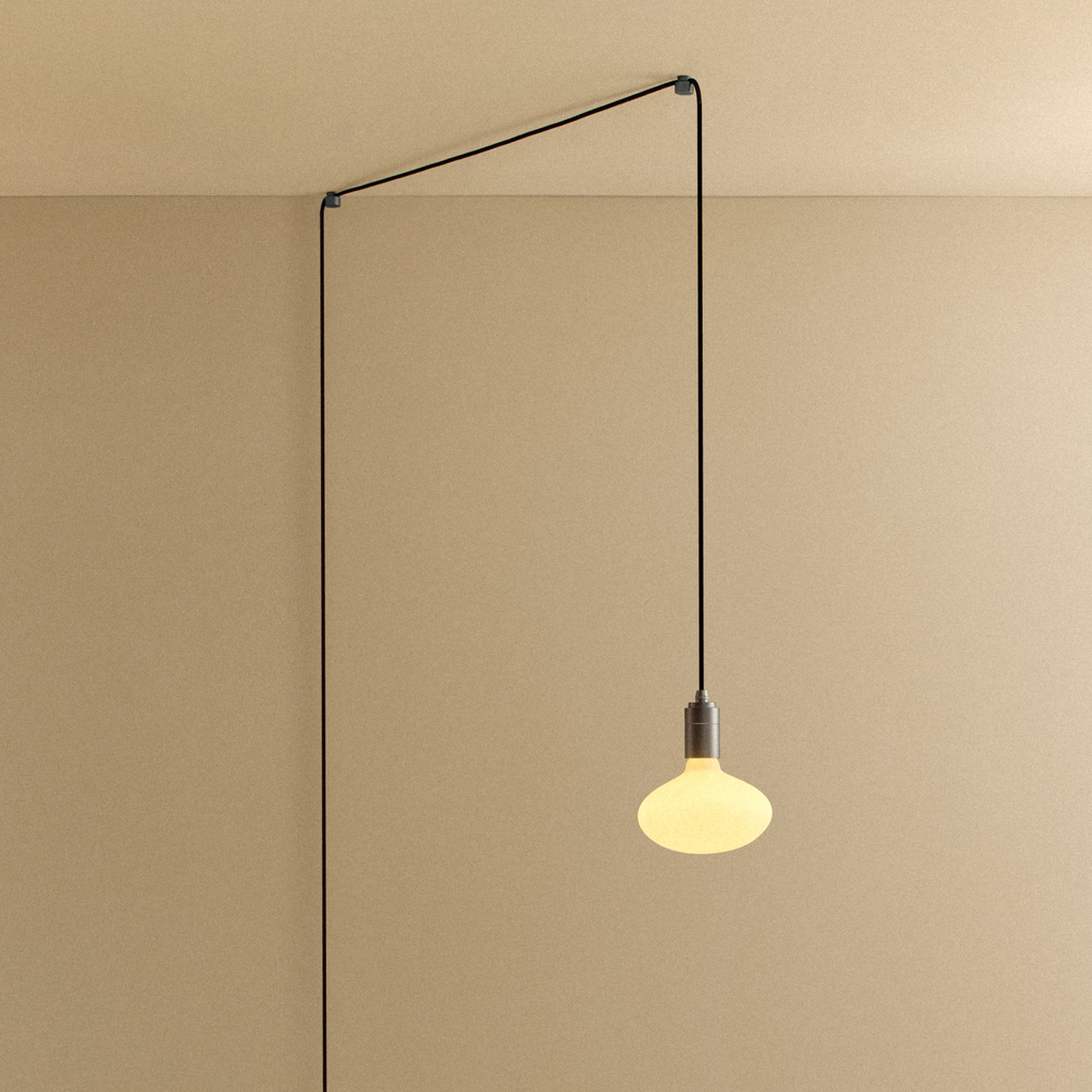 Tala Oval Dim-to-Warm Plug-In Pendant in Graphite shown illuminated