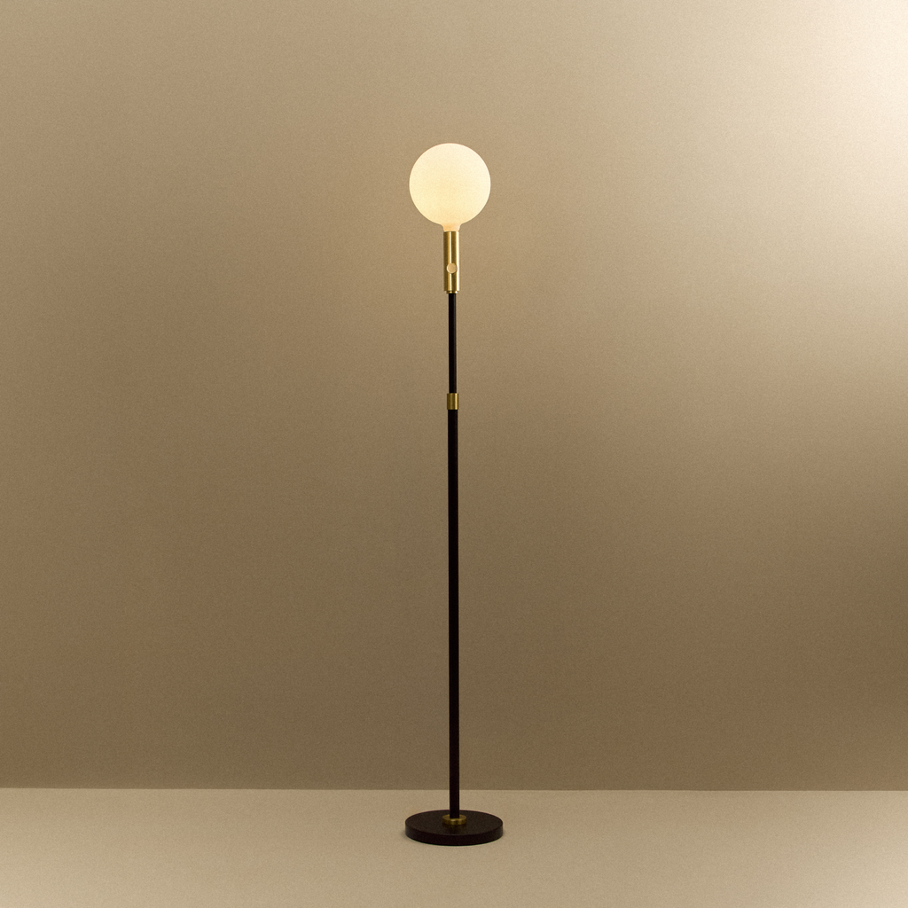 Tala Poise Adjustable Floor Lamp in Brass + Sphere V shown illuminated