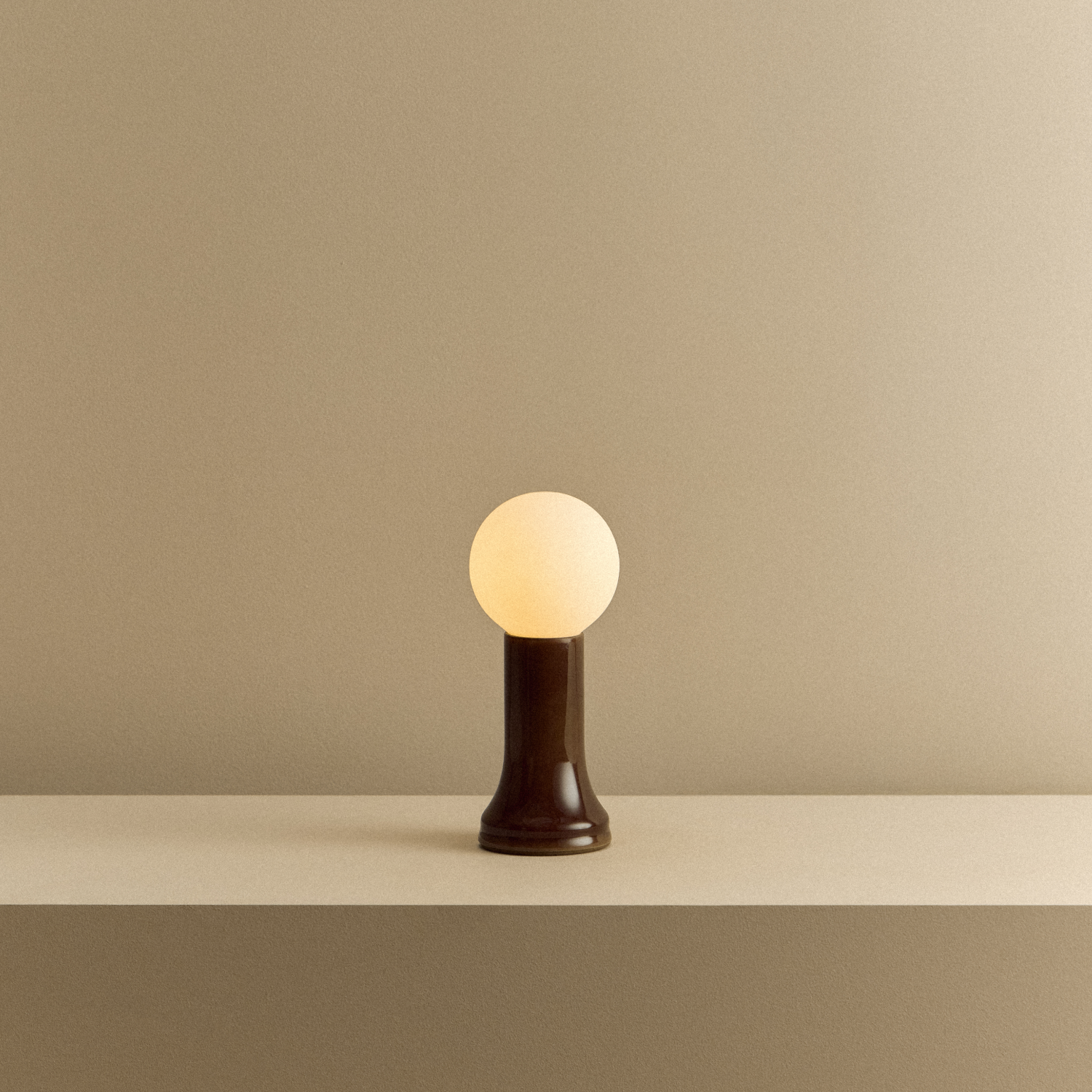 Tala Shore Table Lamp in Bottle Brown shown illuminated
