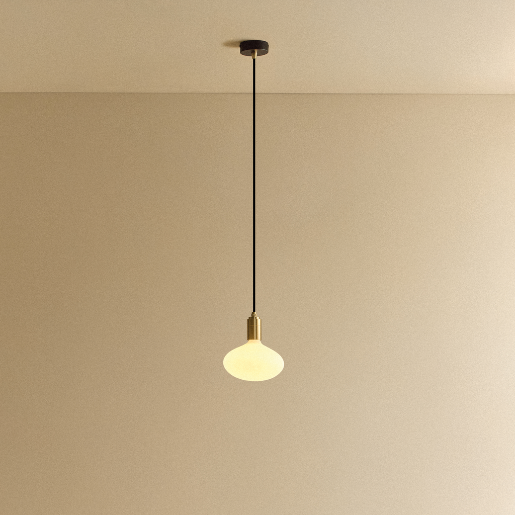 Tala Oval Pendant Light in Brass shown illuminated