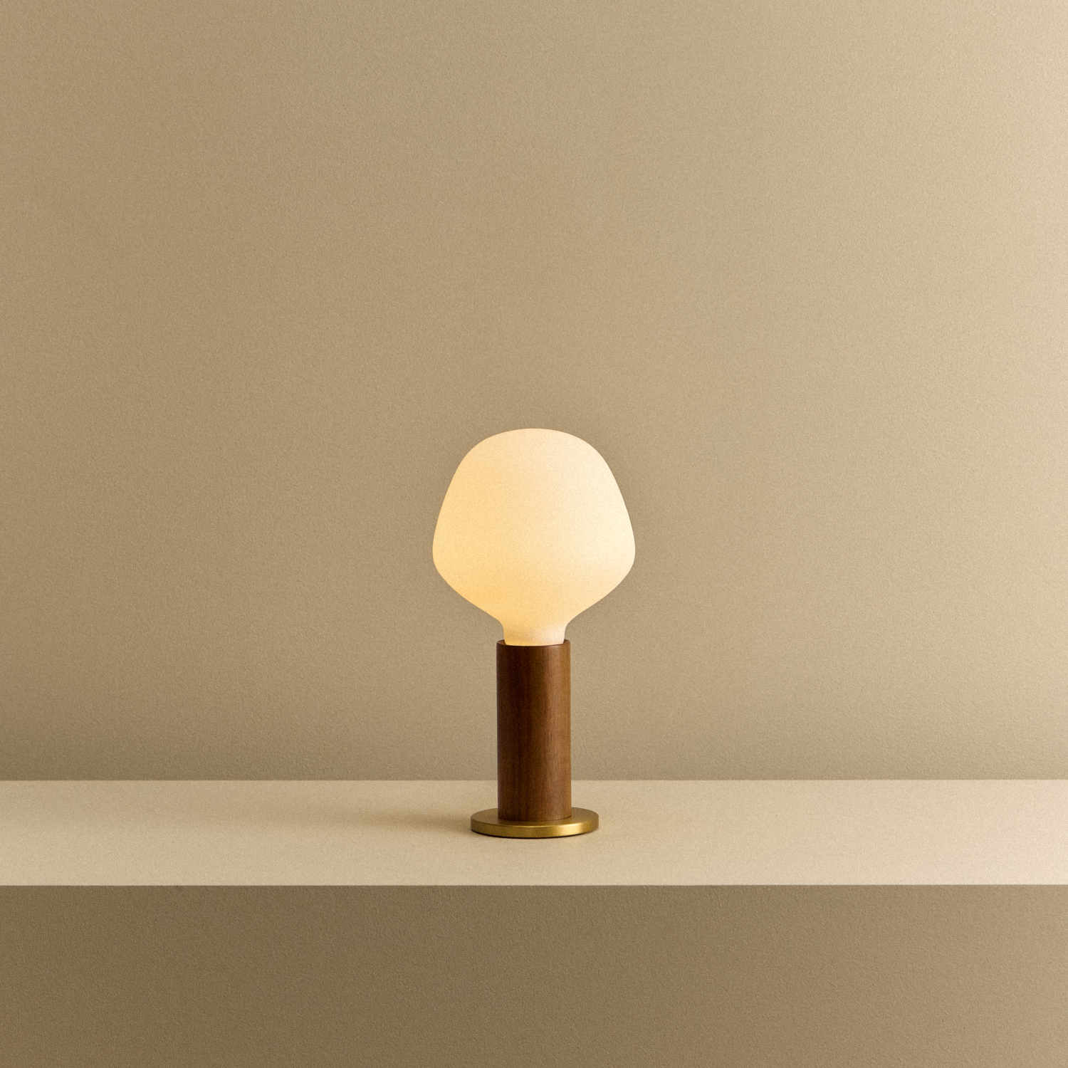 Tala Knuckle Table Lamp in Walnut + Enno shown illuminated
