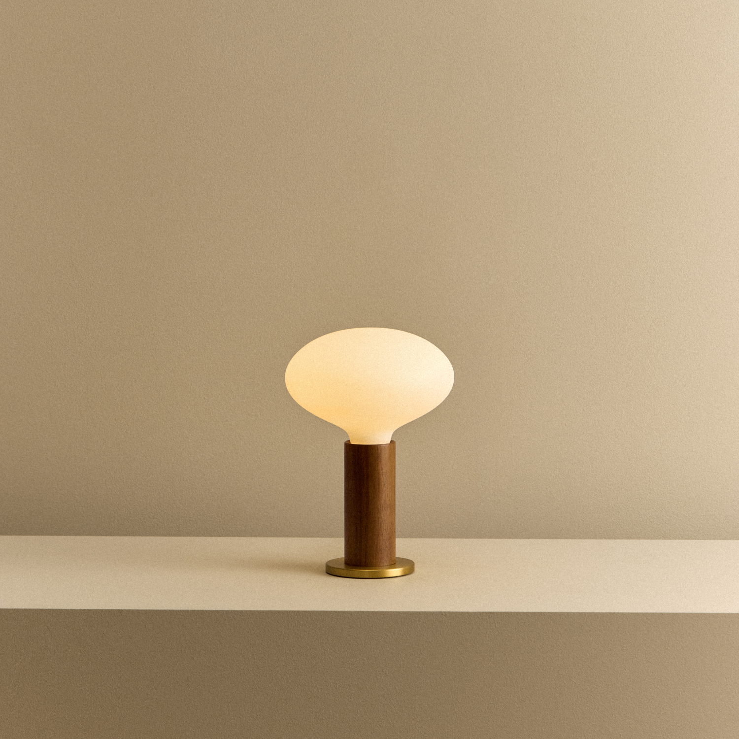Tala Knuckle Table Lamp in Walnut + Oval shown illuminated