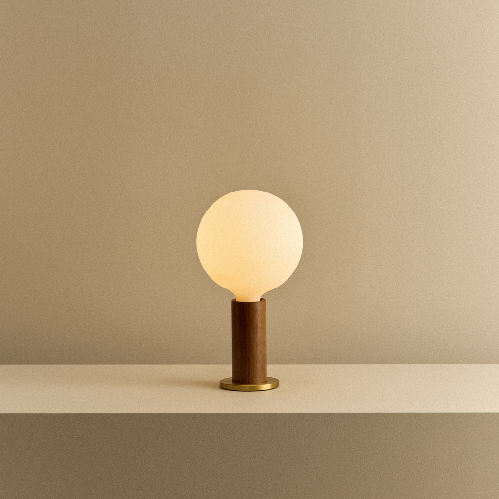 Tala Knuckle Table Lamp in Walnut + Sphere IV shown illuminated